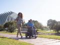 Aviva RX40 lifestyle foto. Ung par ude i solen. Mand i blå el-kørestol, elektrisk kørestol fra Invacare